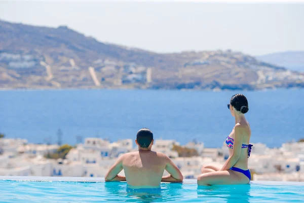 Feliz familia romántica joven disfrutar de la vista en el borde de la piscina — Foto de Stock