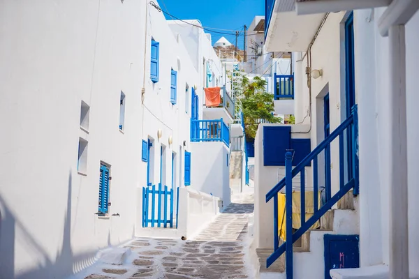 Empty narrow streets of greek island with trees. Beautiful architecture building exterior with cycladic style.