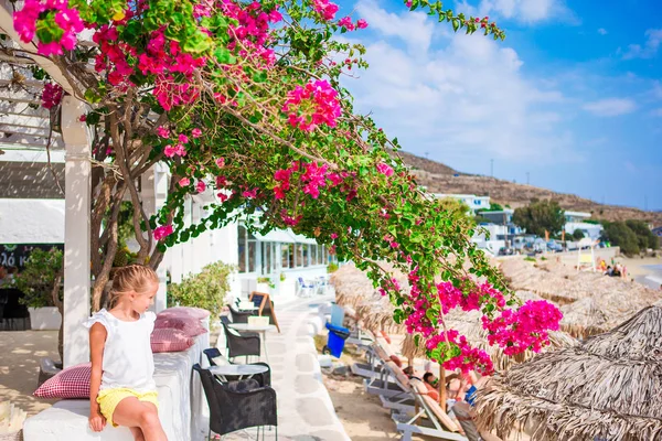 Menina no café da praia com vista para o mar e espreguiçadeiras em férias europeias — Fotografia de Stock