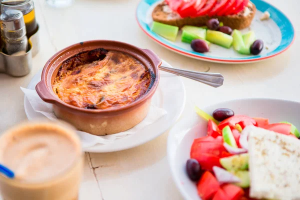 Tradycyjny obiad, pyszne świeże sałatki greckiej, frappe, musaka w kawiarni na świeżym powietrzu z — Zdjęcie stockowe