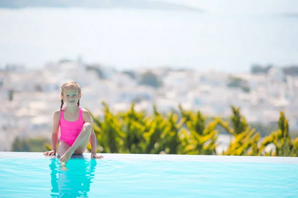 Menina adorável na beira da piscina exterior com bela vista — Fotografia de Stock