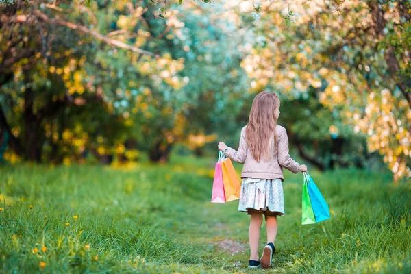 Menina adorável com sacos de compras ao ar livre — Fotografia de Stock