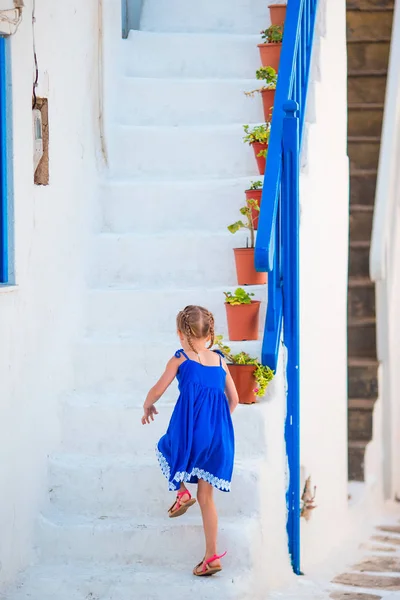 Cute girl in blue dress at street of greek village on Mykonos Island, in Greece — Stock Photo, Image