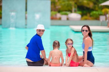 İki çocuklu genç aile keyfini çıkarın tatil yaz Açık Yüzme havuzunda
