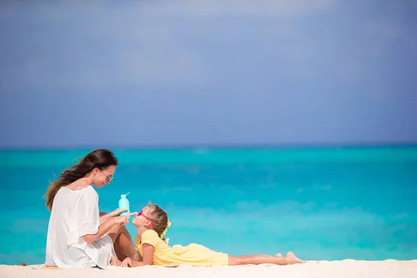 Junge Mutter cremt Tochter im Urlaub an heißen Tagen mit Sonnencreme ein — Stockfoto