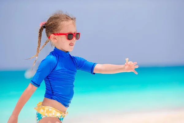 浅い水の中楽しんで白いビーチでのかわいい女の子 — ストック写真