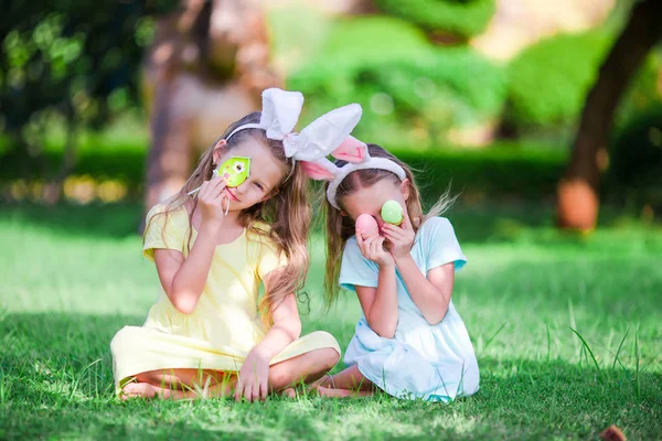 Little cute girls with bunny ears have fun with eggs on Easter holiday — Stock Photo, Image