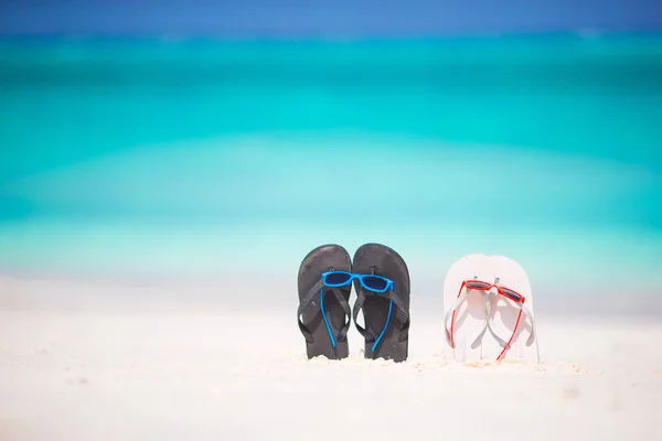 Sommerflip-Flops mit Sonnenbrille am weißen Strand. Nahaufnahme Strand-Accessoires. — Stockfoto