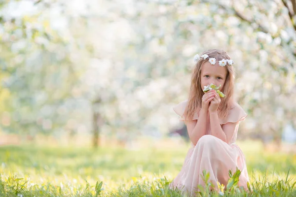 Kleines schönes Mädchen genießt den Duft in einem blühenden Frühlingsgarten — Stockfoto