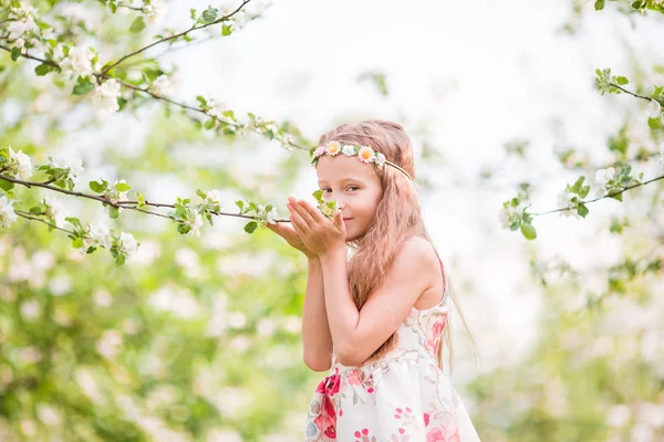 Lilla vackra flicka njuter av doften i en blommande vår apple trädgård — Stockfoto