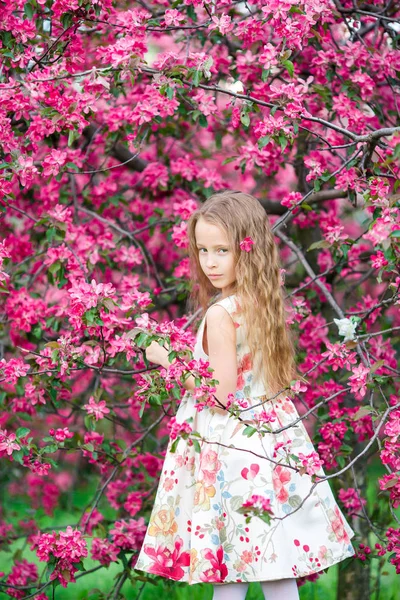 Klein meisje in bloeiende apple tree tuin genieten van het voorjaar — Stockfoto