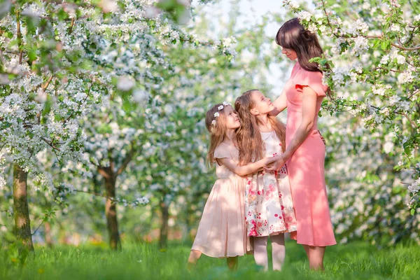 Família no jardim de maçã florescendo ao ar livre — Fotografia de Stock