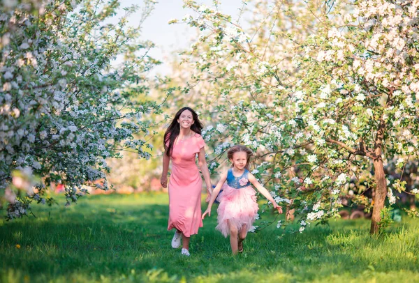 Mãe e filha no jardim florescente desfrutar do dia quente — Fotografia de Stock