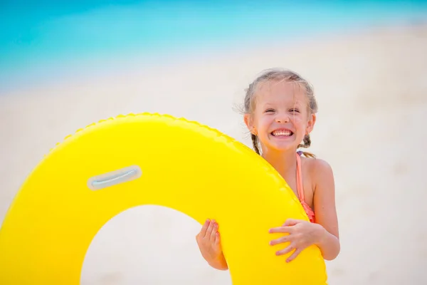 Little girl with inflatable rubber circle on white beach at caribbean vacation — Stock Photo, Image