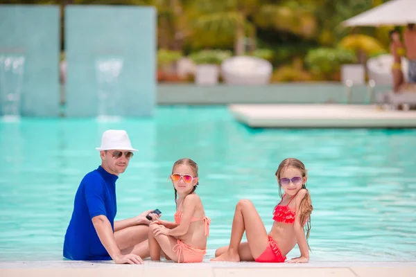 Mała dziewczynka i szczęśliwy ojciec zabawy na skraju basenu — Zdjęcie stockowe