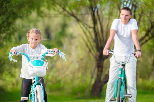 Jovem pai e menina de bicicleta no verão dia quente. Jovem passeio familiar ativo em bicicletas — Fotografia de Stock