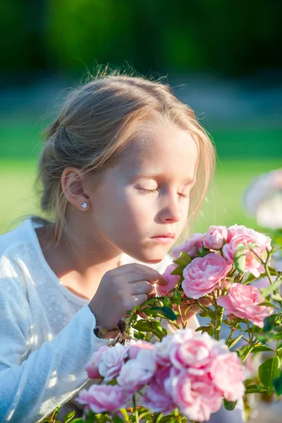 Little adorable girl smelling colorful flowers outdoors — Stock Photo, Image