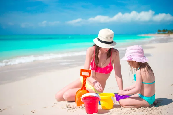 Mère et petite fille faisant château de sable à la plage tropicale — Photo