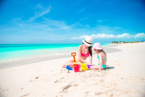 Mamá y pequeño bebé lindo haciendo castillo de arena en la playa tropical — Foto de Stock