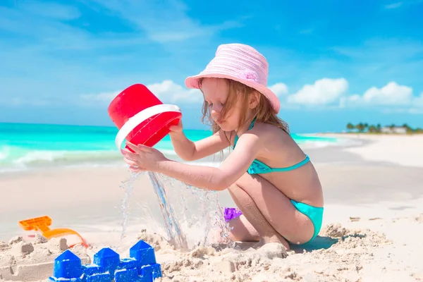 Adorable little girl playing with beach toys on white sandy beach — Stock Photo, Image