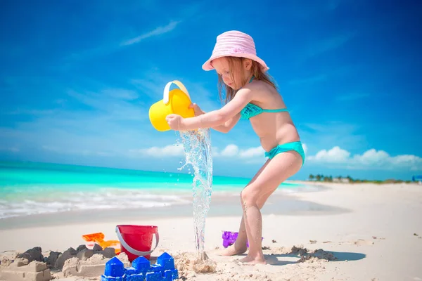 Sevimli küçük kız sahilde plaj oyuncakları ile oynarken — Stok fotoğraf