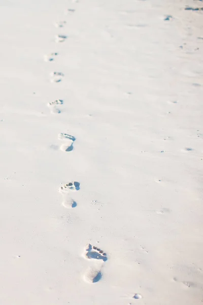 Fußabdrücke im Sand bei Sonnenuntergang. Fußstapfen am Ufer. — Stockfoto