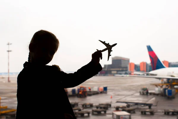 Silhouette of a small airplane model on airport in kids hands — Stock Photo, Image