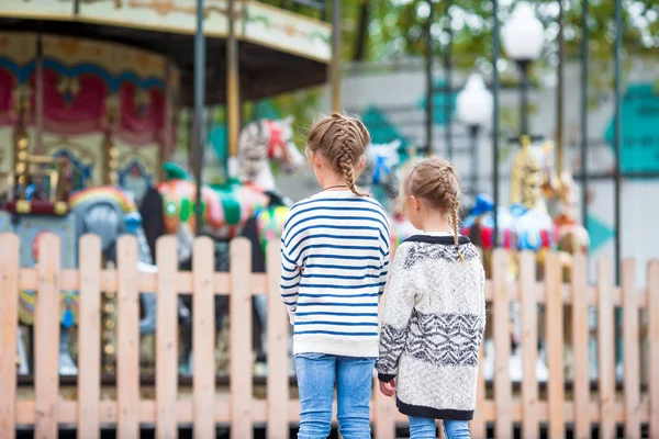 Adorables petites filles près du carrousel dans le parc pour enfants en plein air — Photo