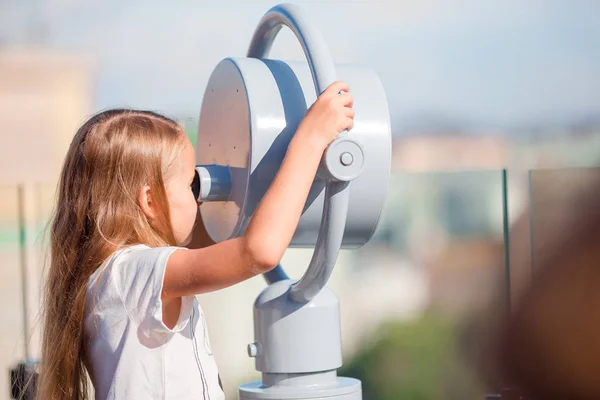 Niña mirando binocular moneda operado en la terraza con hermosa vista — Foto de Stock