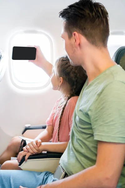 Pai e menina tomando selfie viajando de avião — Fotografia de Stock