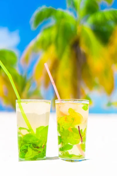 Two cold tasty mohito cocktails on the white sandy beach — Stock Photo, Image