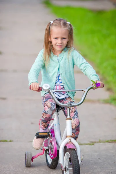 Adorable girl riding a bike at beautiful summer day outdoors Stock Image