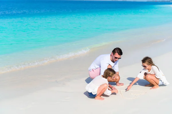 Le jeune père et ses adorables petites filles attirent le cœur sur le sable blanc — Photo