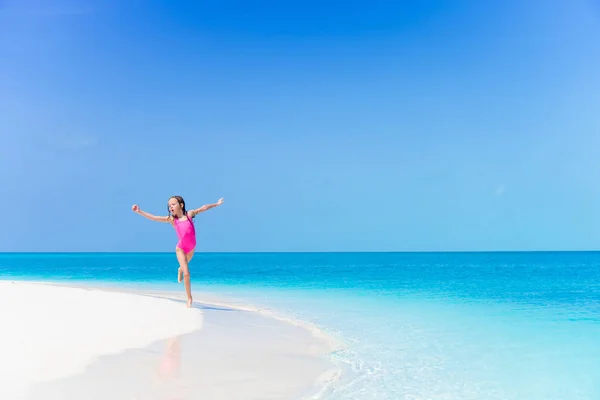 Niña en la playa divirtiéndose mucho en aguas poco profundas en la playa —  Fotos de Stock