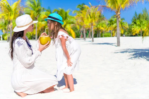 Malá holka a mladá matka s kokosovým mlékem na exotické pláži — Stock fotografie