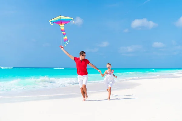 Familia volando cometa juntos en tropical blanco playa — Foto de Stock