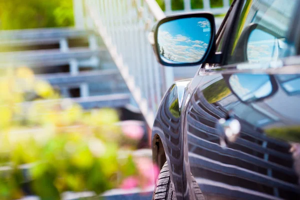 Espejo. Reflejo del cielo azul soleado en el espejo lateral del coche . — Foto de Stock