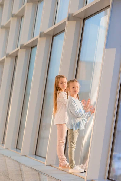 Petites filles à l'aéroport près de la grande fenêtre en attendant l'embarquement — Photo