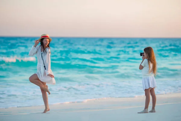 Little cute girl taking photo of her mom at tropical beach — Stock Photo, Image