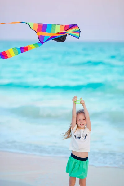 Piccola ragazza in corsa con aquilone volante sulla spiaggia tropicale. Il ragazzo gioca sulla riva dell'oceano. Bambino con giocattoli da spiaggia . — Foto Stock