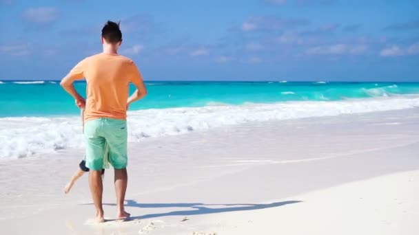 Menina e jovem pai se divertindo durante as férias na praia tropical. LOW MOTION . — Vídeo de Stock