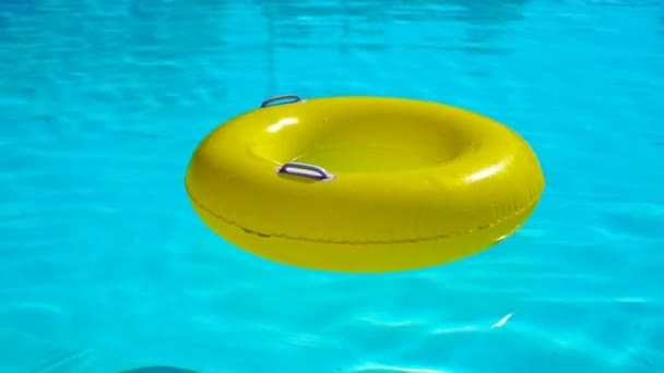 Swimming pool with a brightly yellow inflatable ring — Stock Video