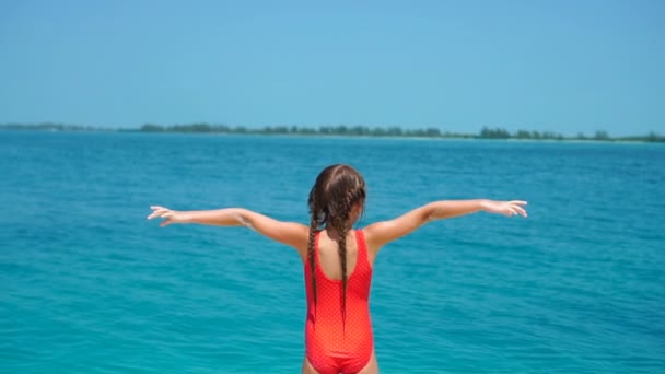 Adorable little girl at beach having a lot of fun on summer holidays. Funny girl in slow motion video — Stock Video