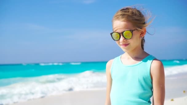 Kleines Mädchen am weißen Strand. Porträt eines entzückenden Kindes in ihrem tropischen Sommerurlaub — Stockvideo
