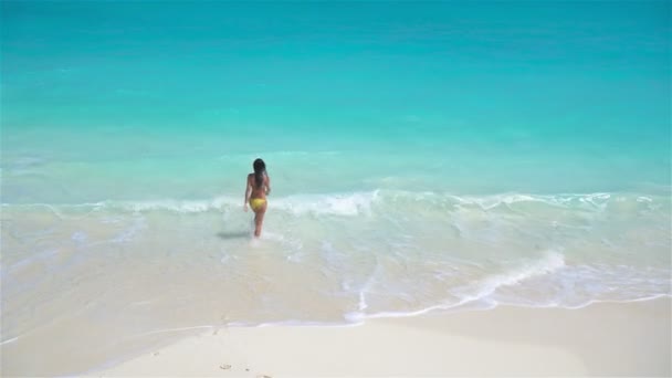 Kumsaldaki sevimli küçük kız sığ sularda çok eğleniyor. — Stok video