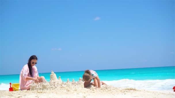 Mamma och lilla söta bebis att göra sandslott på tropical beach — Stockvideo