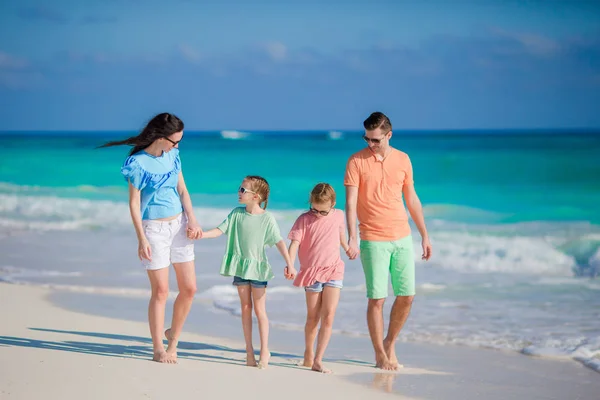 Familia de cuatro en una playa tropical — Foto de Stock