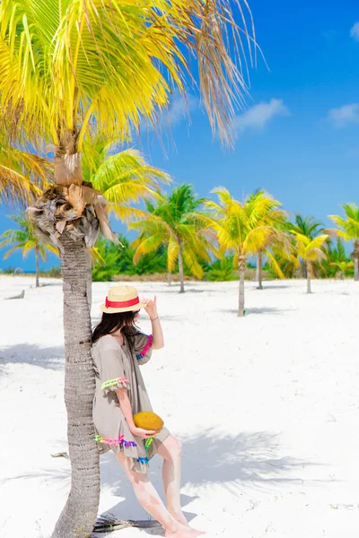 Young beautiful woman on tropical beach with palmtrees — Stock Photo, Image