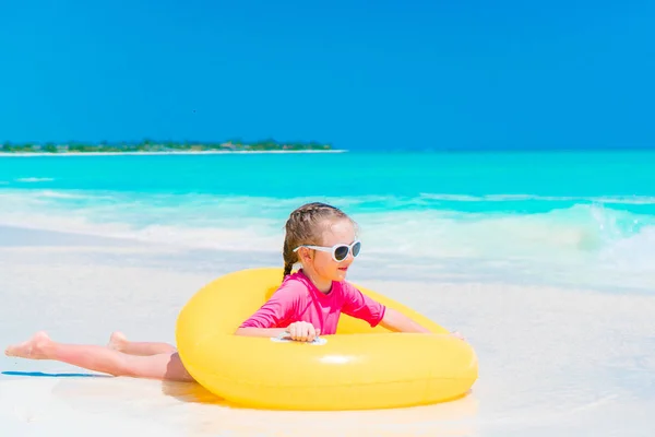 Szczęśliwy dzieciak z nadmuchiwanym gumowym kółkiem bawiący się na plaży — Zdjęcie stockowe