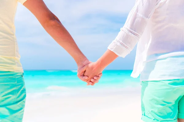 Young couple holding hands at tropical beach — Stock Photo, Image